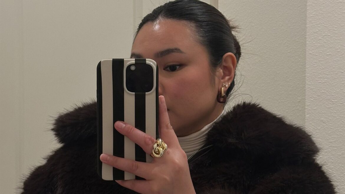 marina takes mirror selfie while wearing faux fur jacket
