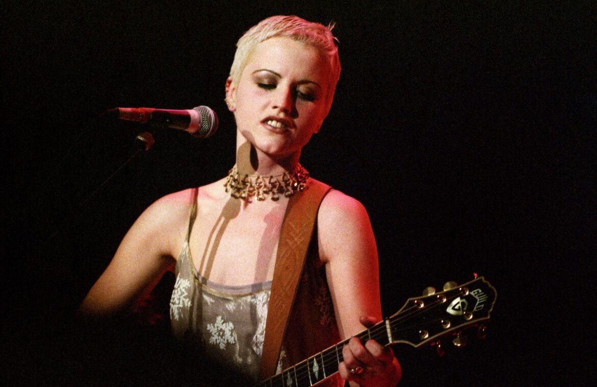 Singer and guitarist Dolores O'Riordan of the Cranberries performs on stage in 1995. (Credit: Pete Still/Redferns)